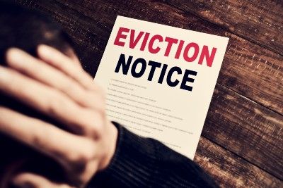 Man looking at eviction notice holds head in hands