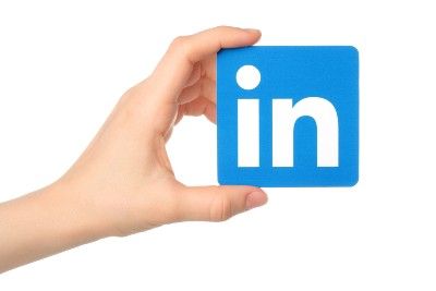Hand holding square LinkedIn logo