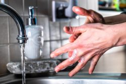 person washing hands to prevent COVID-19