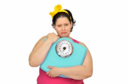 unhappy obese woman with scale