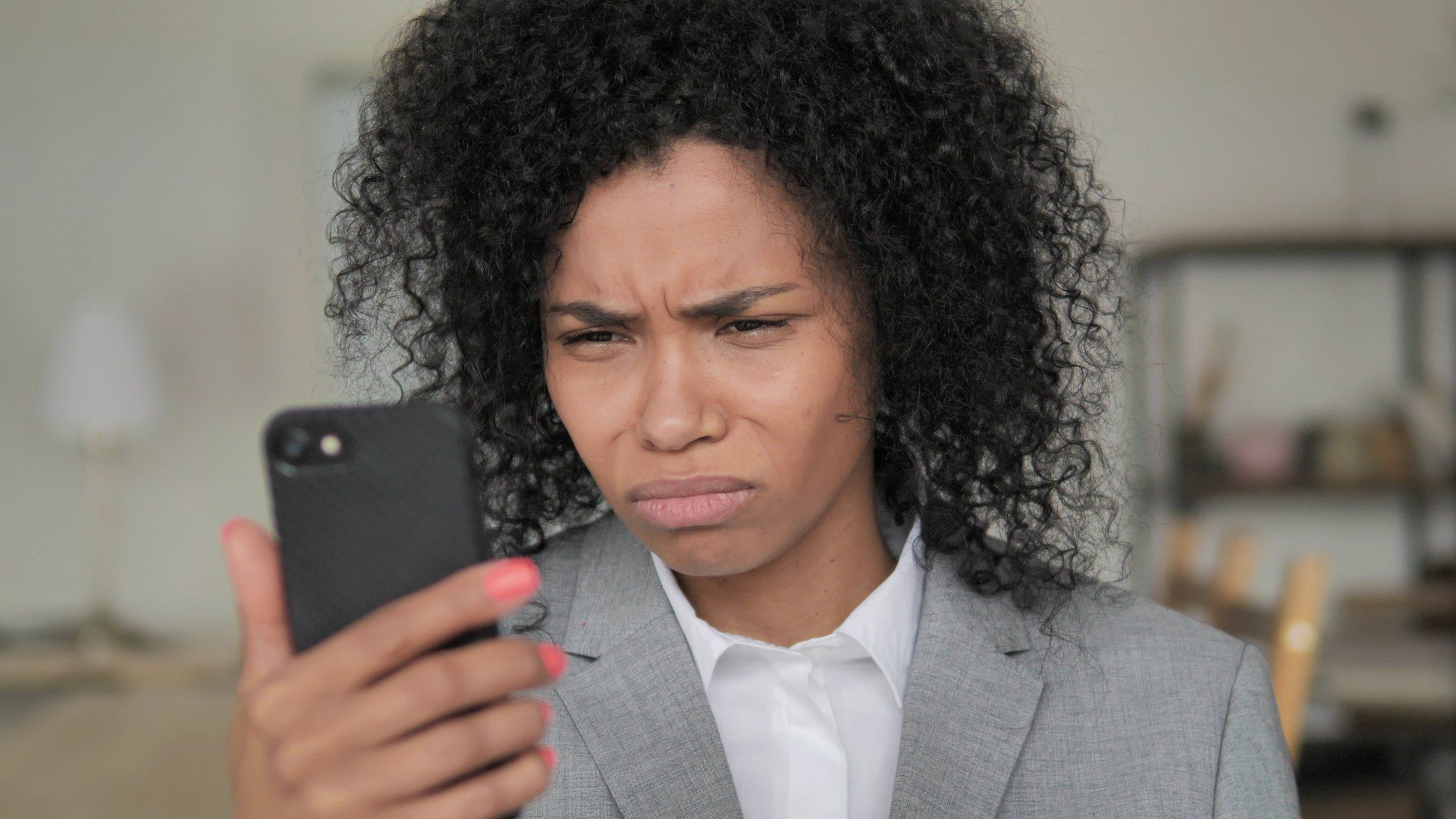 Unhappy woman looking at smart phone