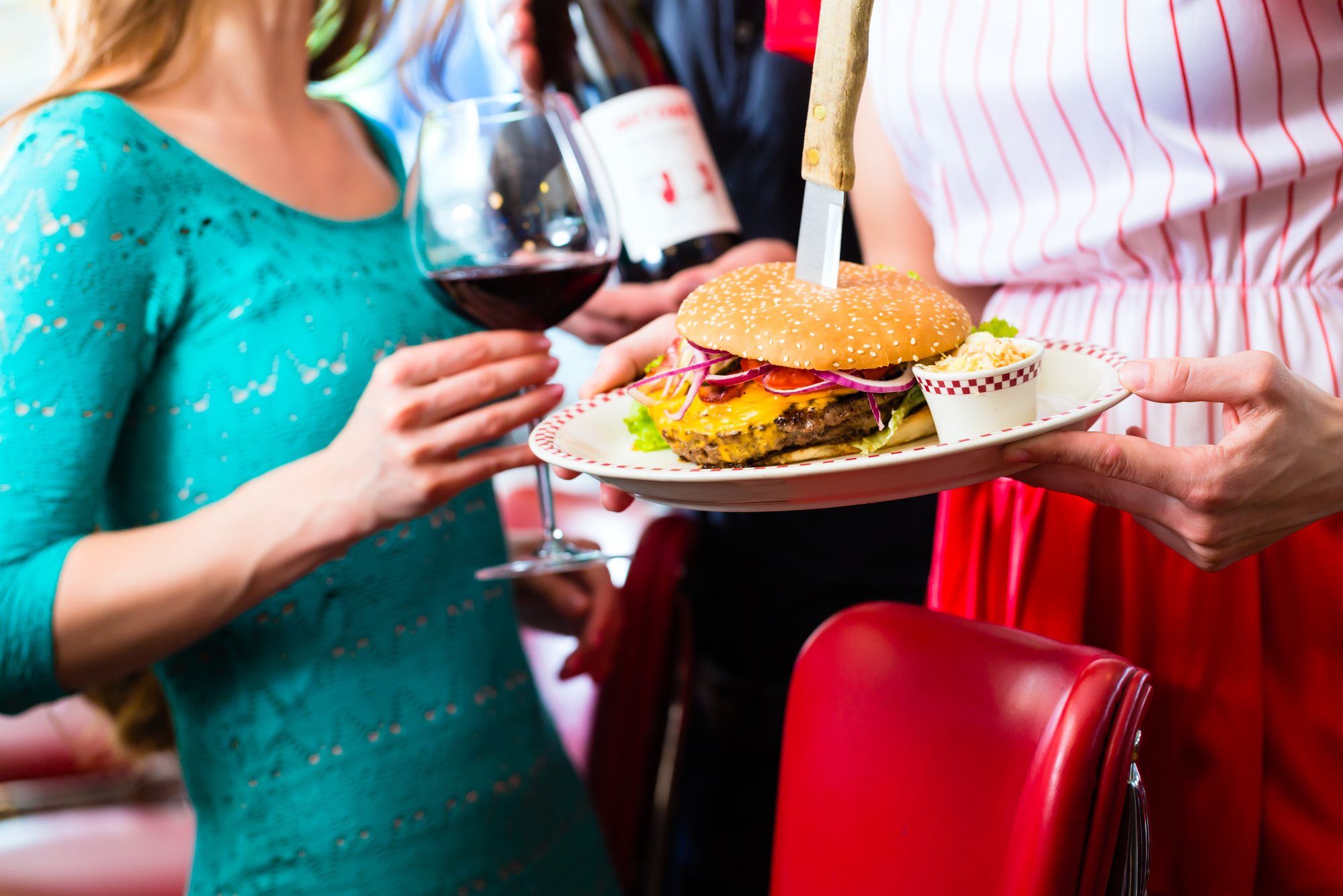 waitstaff serving burgers to customers in bar