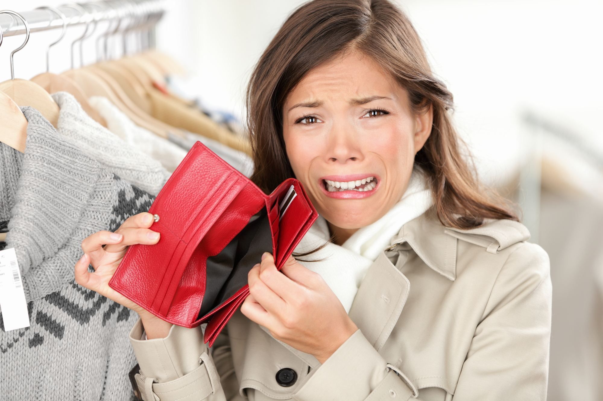 Upset female shopper shows wallet with no money
