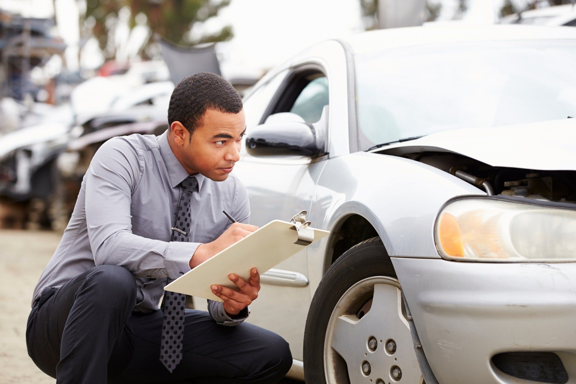 Insurance adjuster inspects damaged vehicle