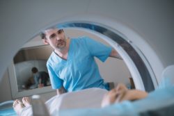 Radiologist looks at patient on MRI machine