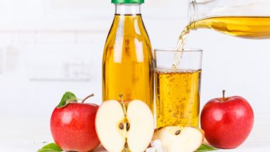 Sliced and whole apples sit next to a bottle of apple juice as someone pours juice into a glass - Mott's 100% Apple Juice