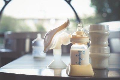 A manual breast pump is shown next to a baby bottle full of milk - Chipotle employees