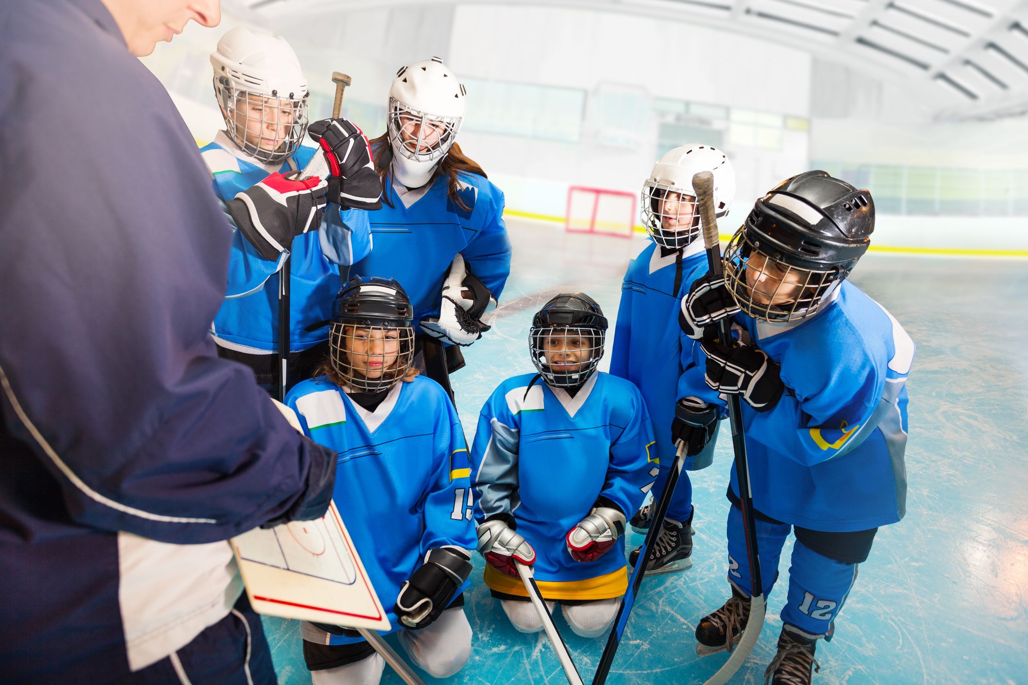 Young hockey players huddle with their coach
