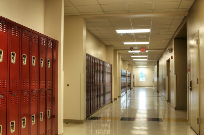 Lockers line empty school hallway