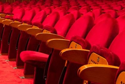 Empty red velvet theater seats with wooden arms - Viagogo refund