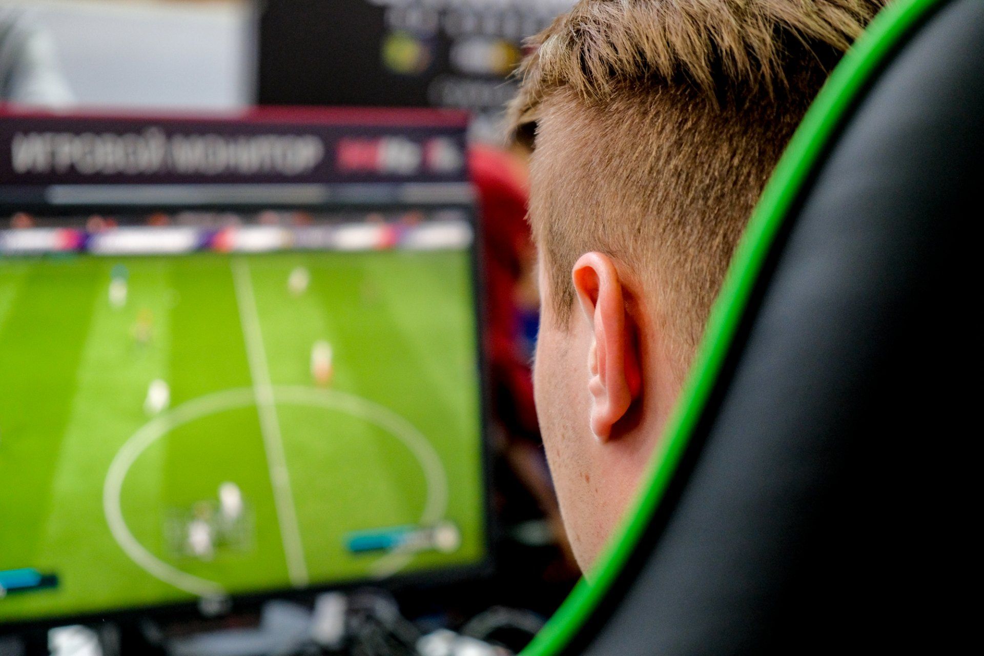 View over the shoulder of a man playing a soccer video game - EA Games