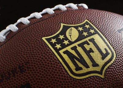 Closeup of gold NFL shield logo on fooball - NFL players