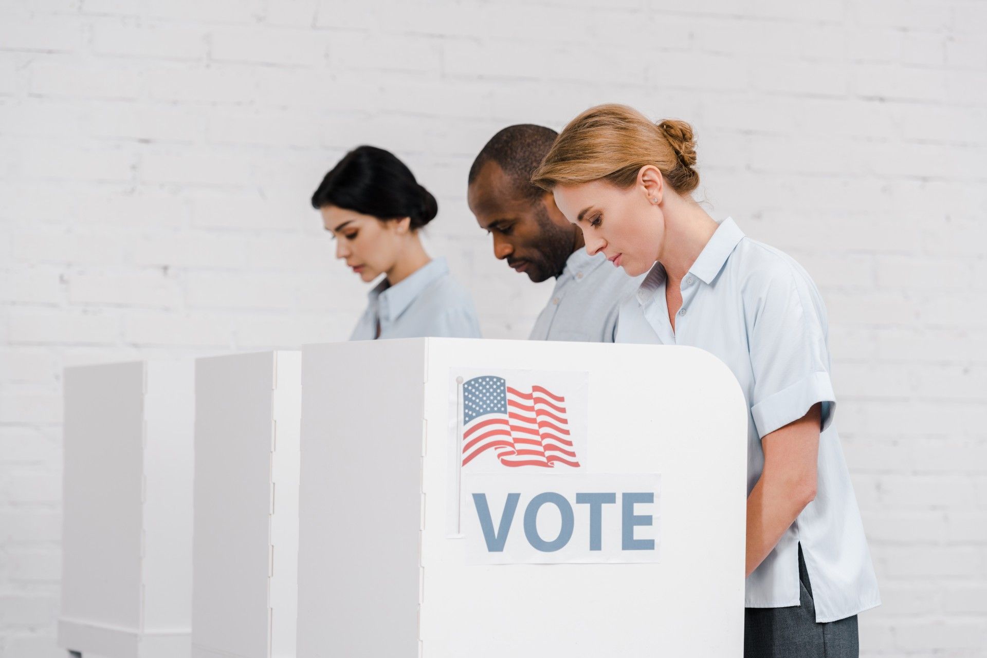 Two women and a man are shown voting at a U.S. polling place - Georgia voters
