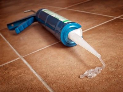 Clear sealant coming out of tube onto brown tile - dap clear sealant