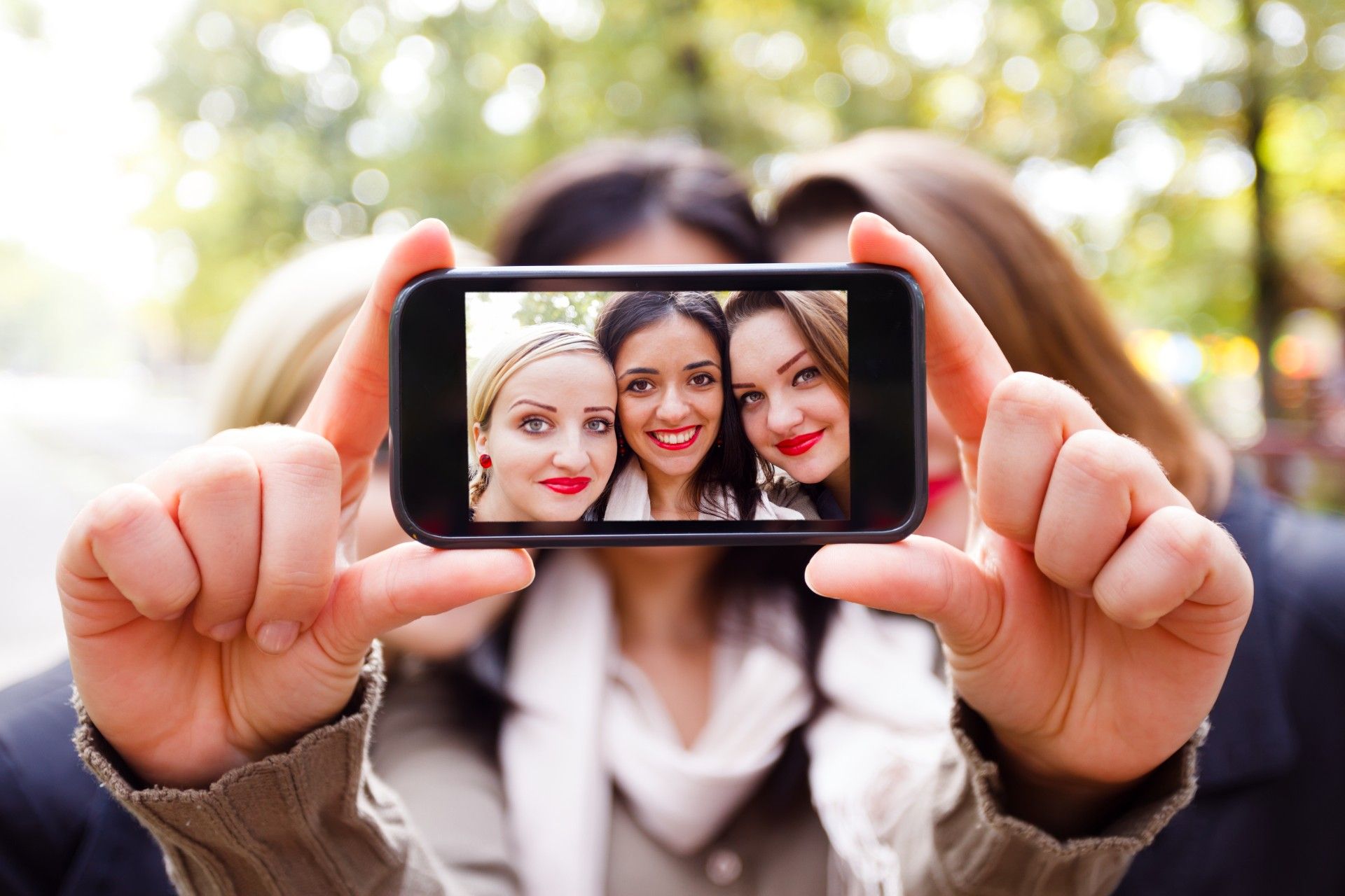 Three women in red lipstick take a selfie as shown on a smartphone screen - Instagram photos