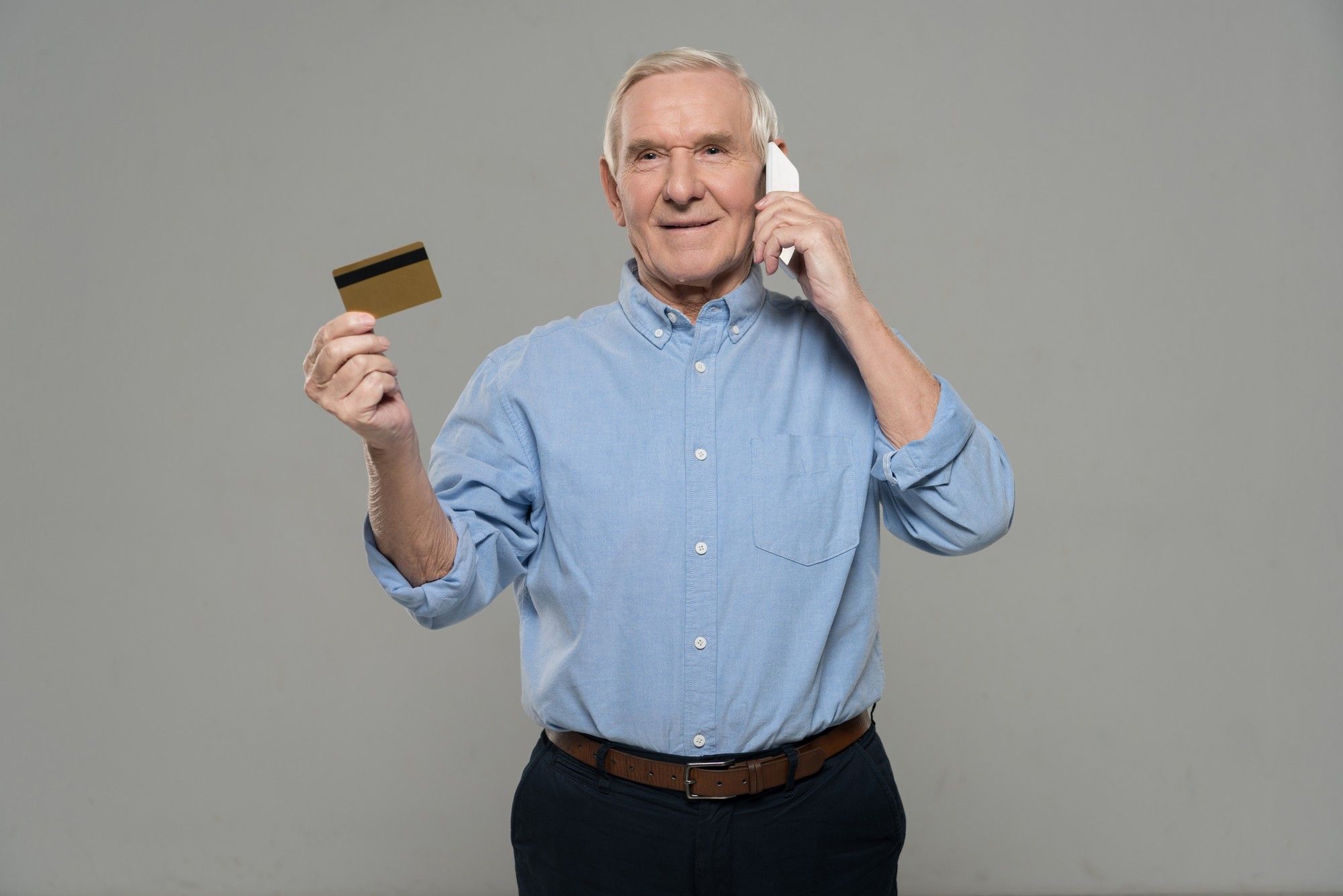older man paying bills by phone