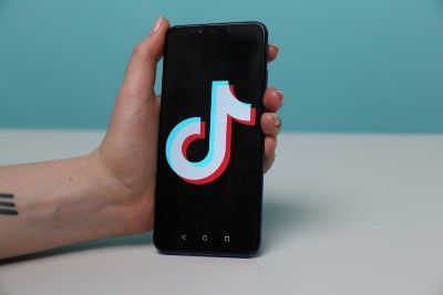 A hand holds an Android smartphone showing the TikTok logo - Google employees 