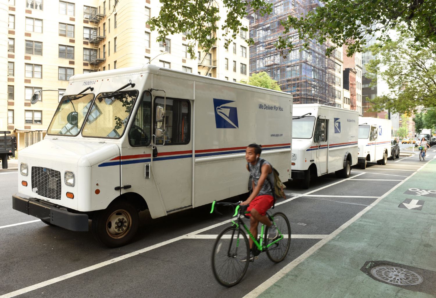 US Postal Service trucks on city street - Voting by mail ahead of Election Day
