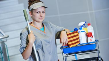 Hospital cleaning staffer with cart of chemicals