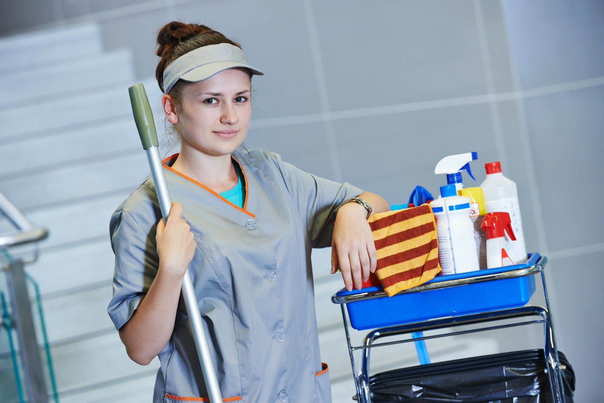 Hospital cleaning staffer with cart of chemicals