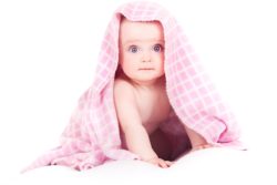 Baby covered in pink towel after bath