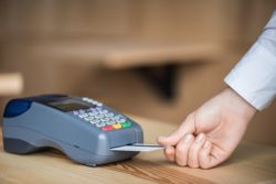 Hand places prepaid debit card into retail payment terminal