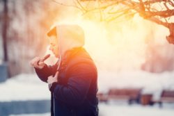 Man vaping outdoors in cold weather