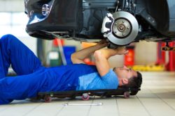 Automotive technician works under a car