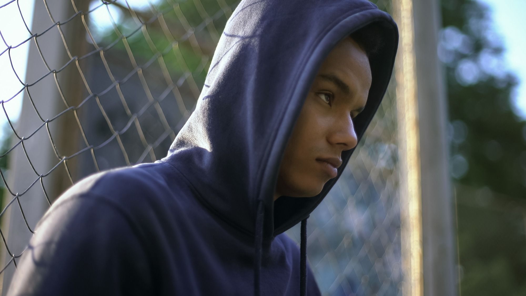 Sad teen boy in navy blue hoodie