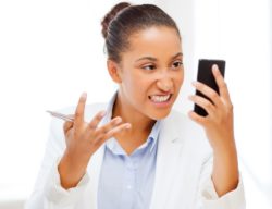 Woman looks angrily at her cell phone