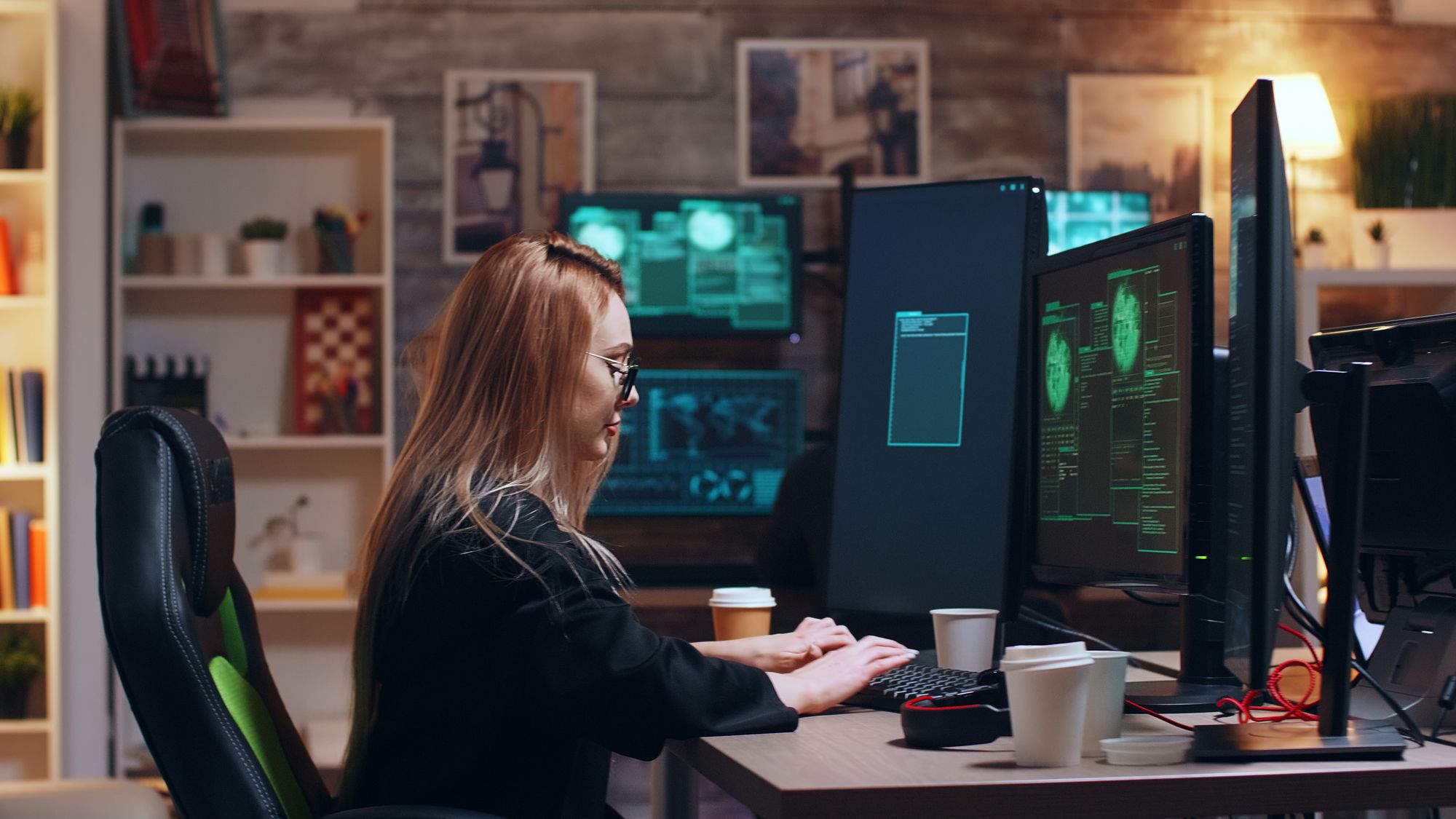 Woman hacking computer data with multiple large screens