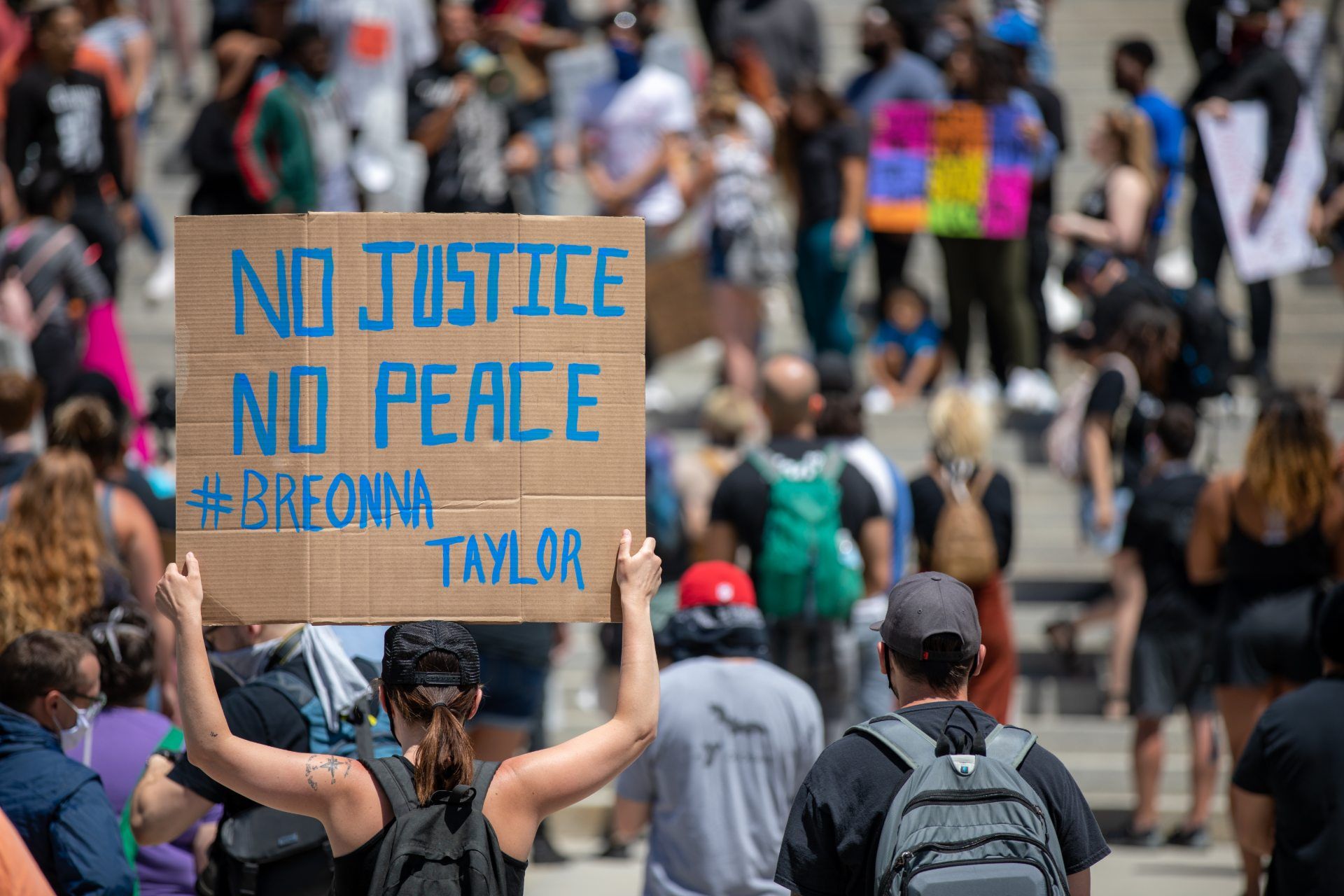A protester holds a sign that reads "No Justice No Peace #Breonna Taylor" - wrongful death