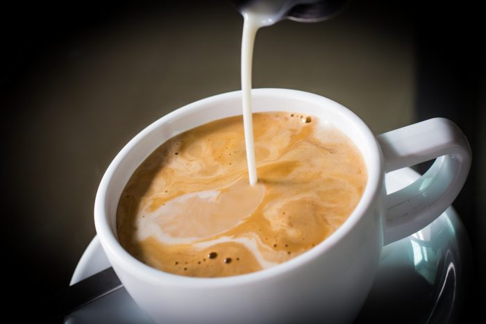 Coffee mate creamer being poured into a cup of coffee