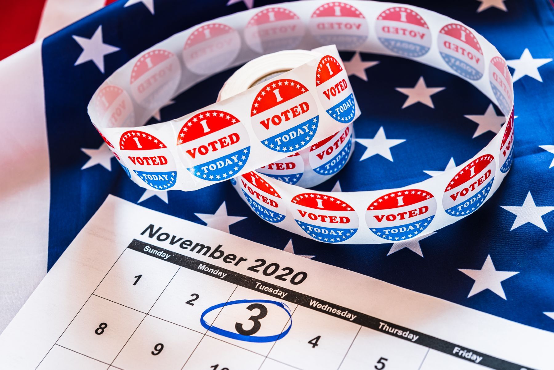 A calendar shows Nov. 3 circled in blue, lies next to "I voted today" stickers and a U.S. flag - early voting
