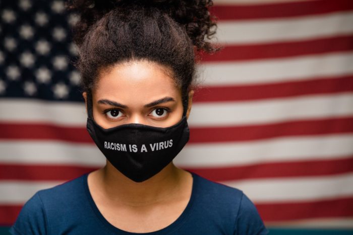 woman wearing racism is a virus face mask