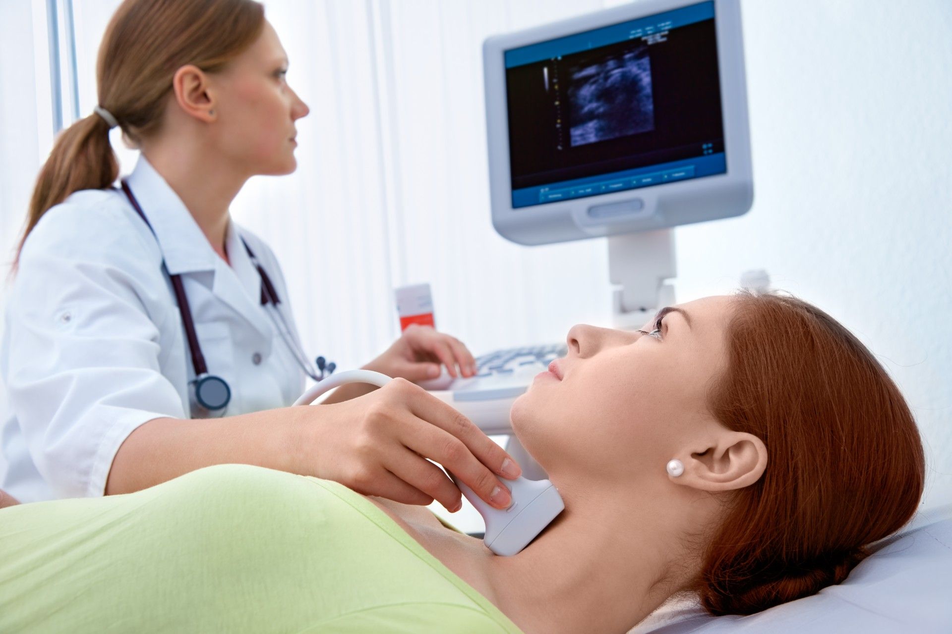 A doctor performs a thyroid ultrasound on a female patient - thyroid medication