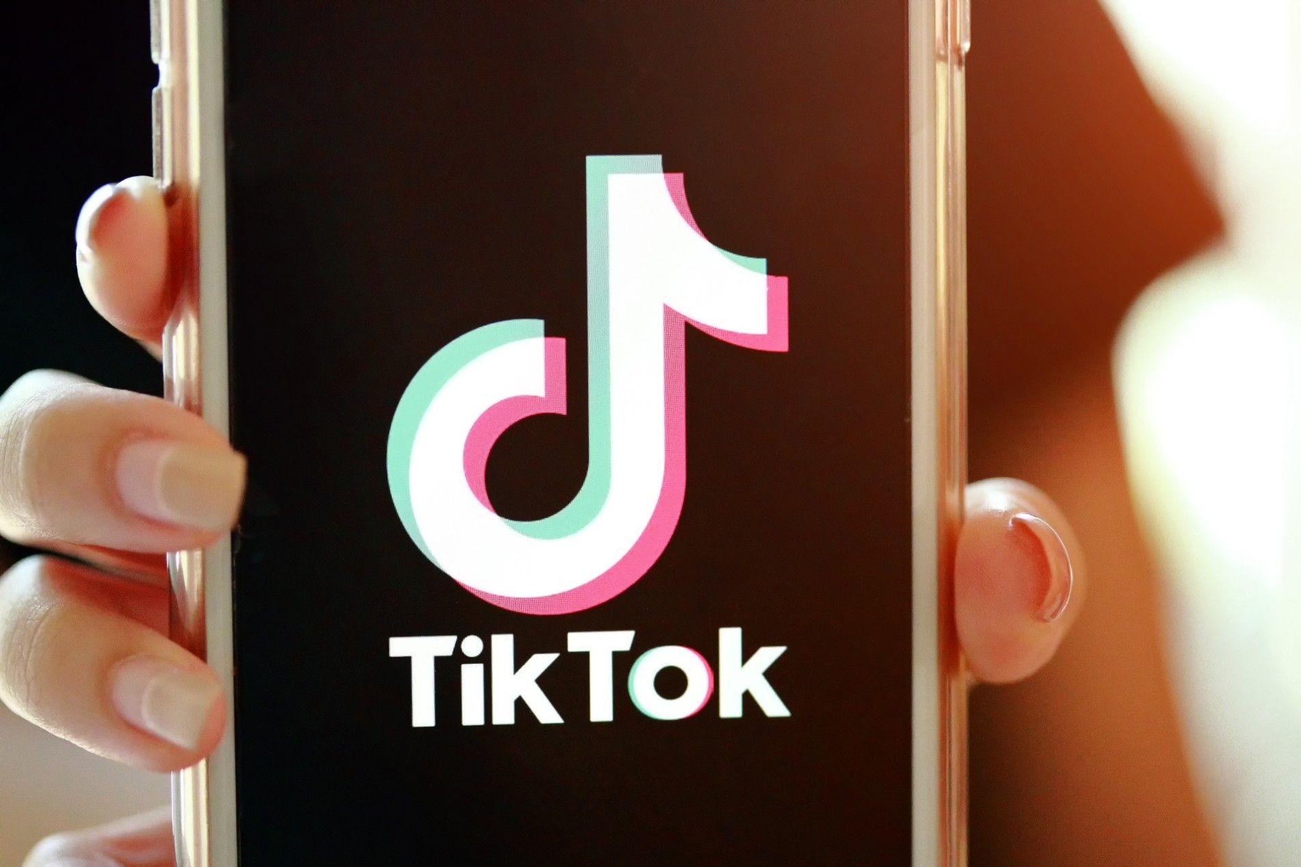 A person holds up a smartphone with TikTok on the screen - tiktok ban