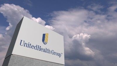 UnitedHealth Group sign under partly cloudy sky - AARP