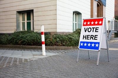 A "vote here" sign stands outside a building - police force