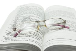 Eyeglasses sit atop open bible
