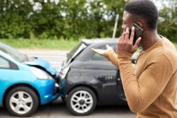 Man on cell phone after car crash