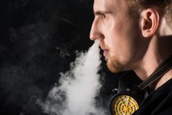 Young man blowing vaping cloud out his nose
