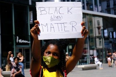 A protester holds a "Black Lives Matter" sign - racial discrimination