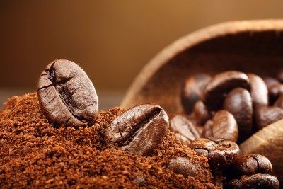 Coffee beans sit in a pile of ground coffee - Keurig single-serve coffee