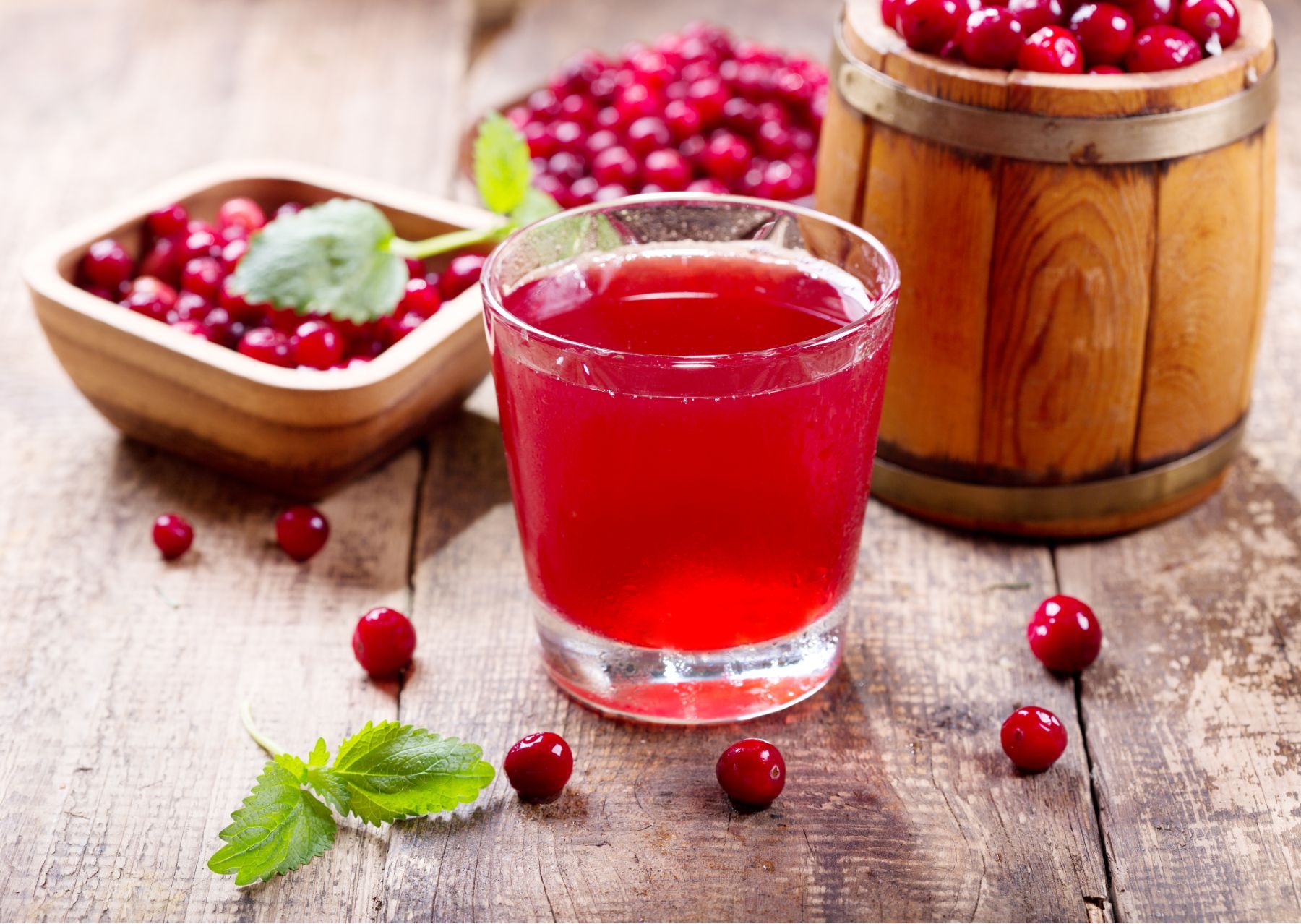 Cranberry juice in a glass surrounded by cranberries - Ocean Spray class action settlement