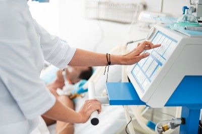 Woman touches the monitor on a hospital ventilator - ventilators
