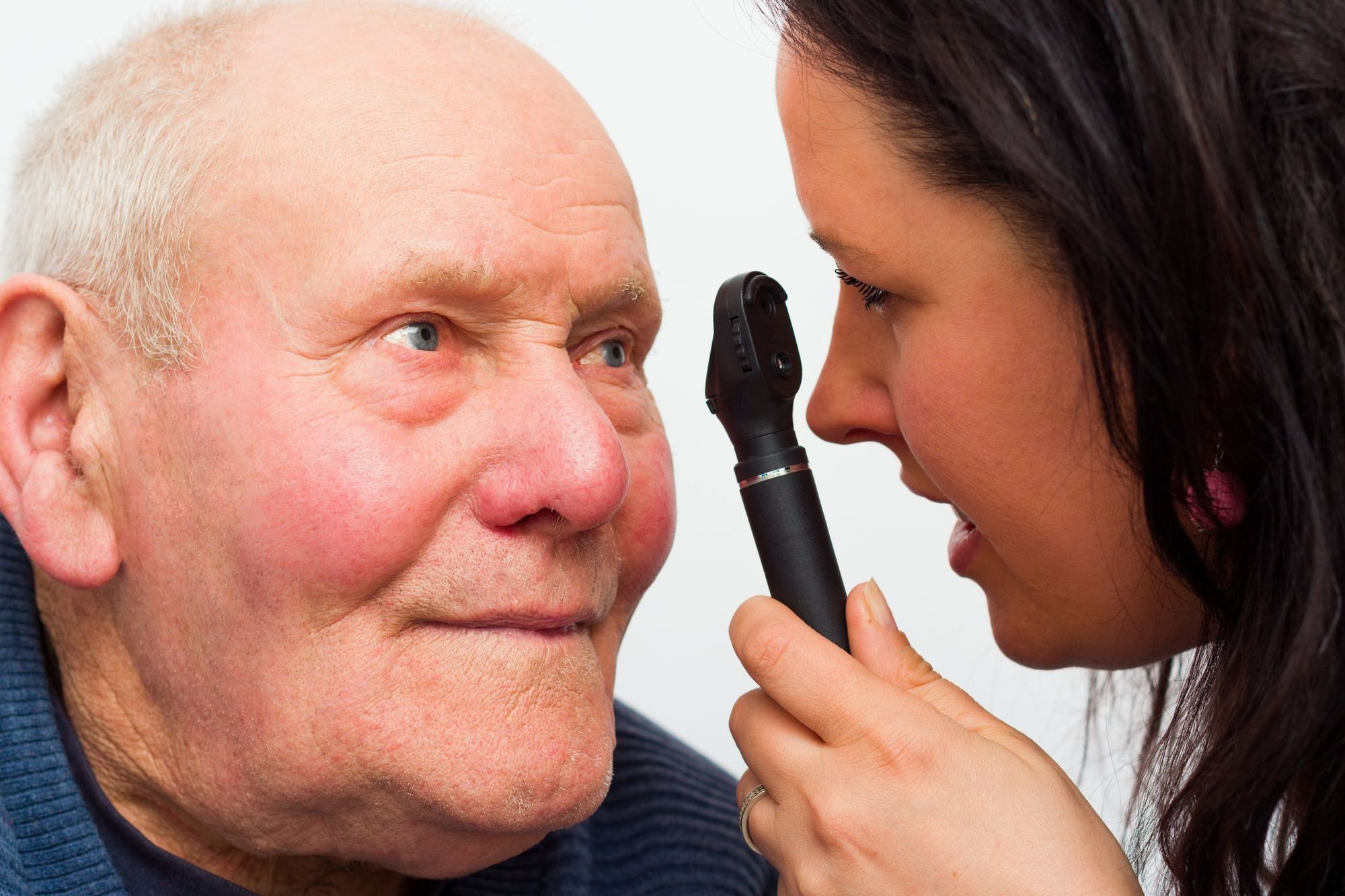 Elderly man has eyes checked by optometrist
