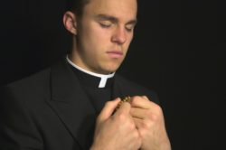 Young priest praying