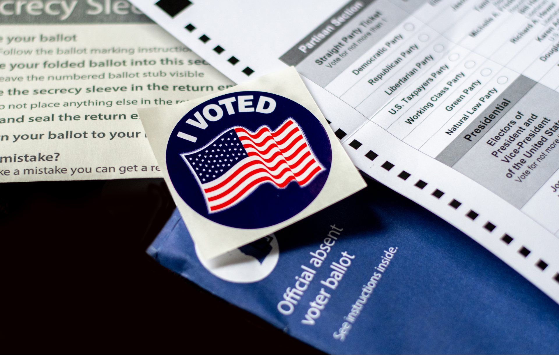 An "I voted" sticker lies near an absentee ballot and envelope - pennsylvania voters