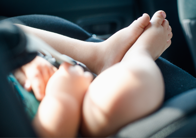 A baby's feet are seen as the child sits in a car seat - Graco car seats